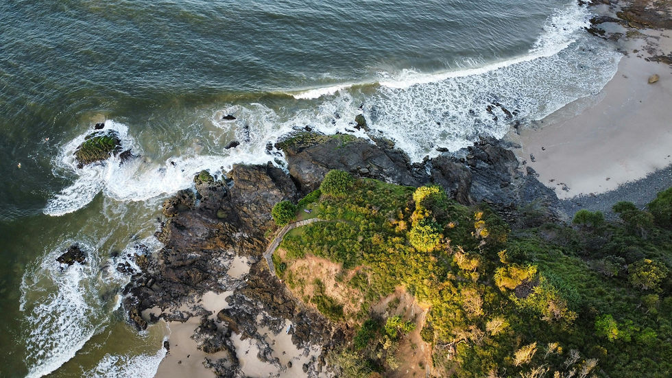 Aerial view of waves crashing against a rocky coastline.