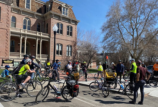 Approximately 25 people standing on/near bikes in front of Morrill Hall on the University of Nevada, Reno campus on a sunny day.