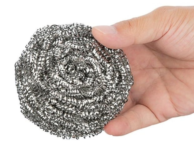 Person holding stainless steel scourer