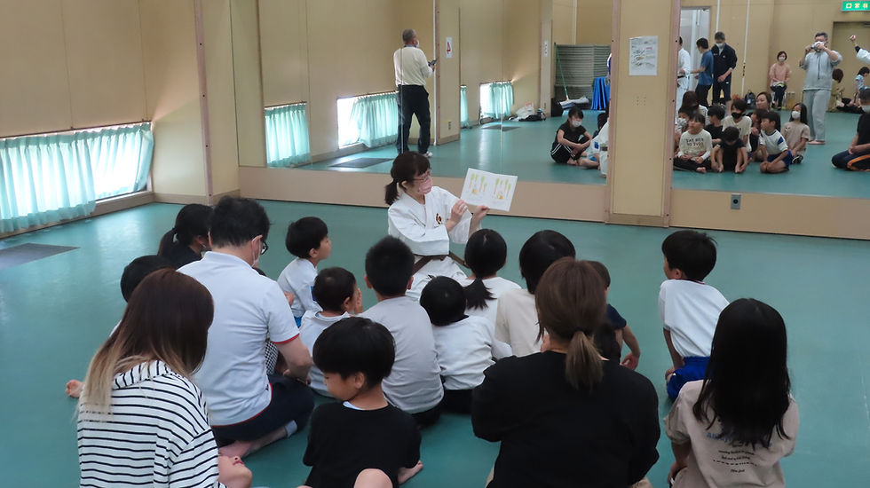 三田市市民スポーツ教室で三田南道院の女性拳士が子供たちに絵本の読み聞かせをしている様子