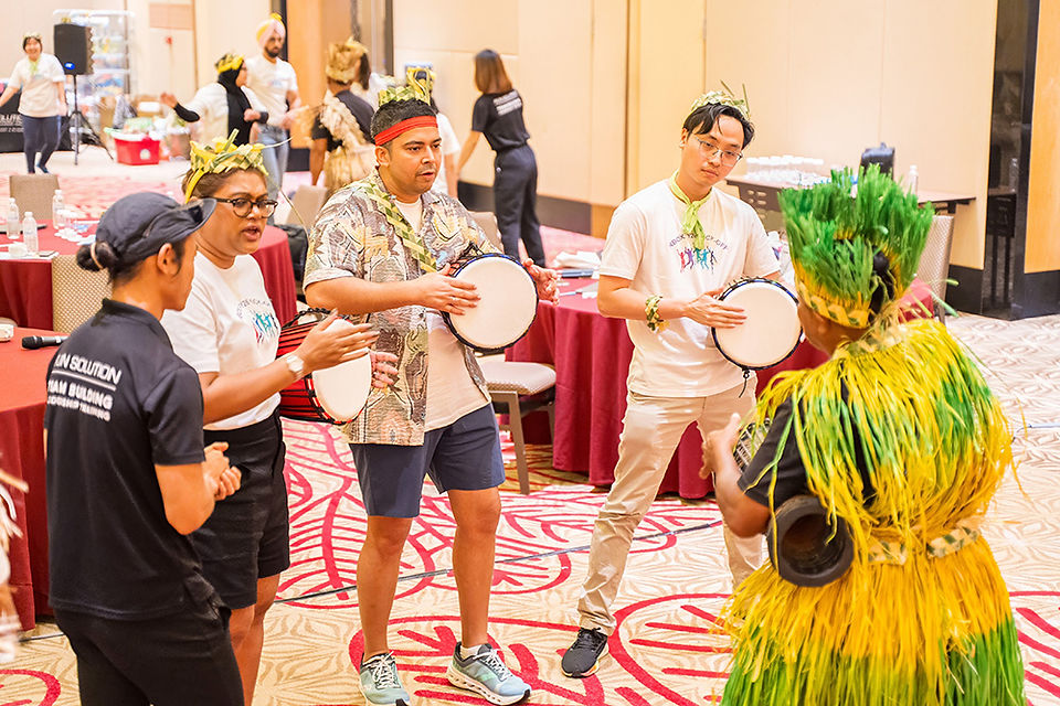 Corporate staff drumming together during music team building retreat in Desaru westin