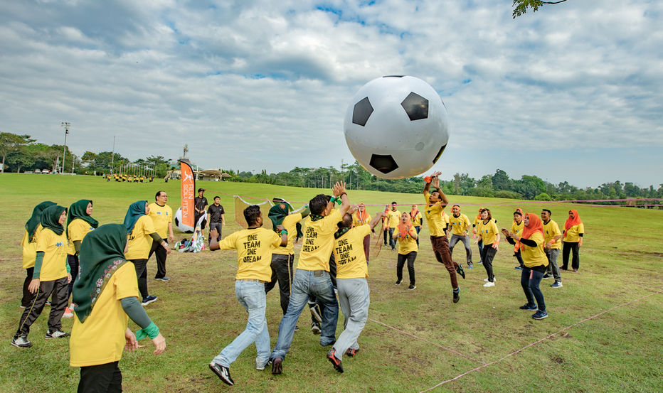 Participants playing outdoor team building games in JB to strengthen teamwork.