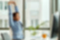 young-smiling-businesswoman-stretching-with-her-eyes-closed-while-working-computer-office.