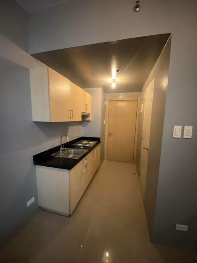 Modern galley kitchen in AA2000 unit with dark counters.