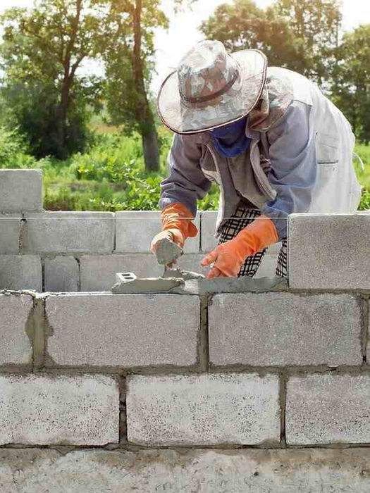 Construction worker building a cinder block wall