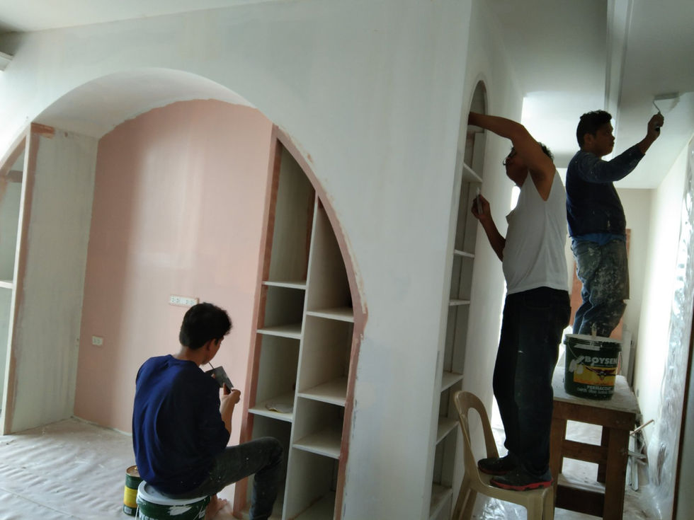 Workers installing custom arched shelving in a home.