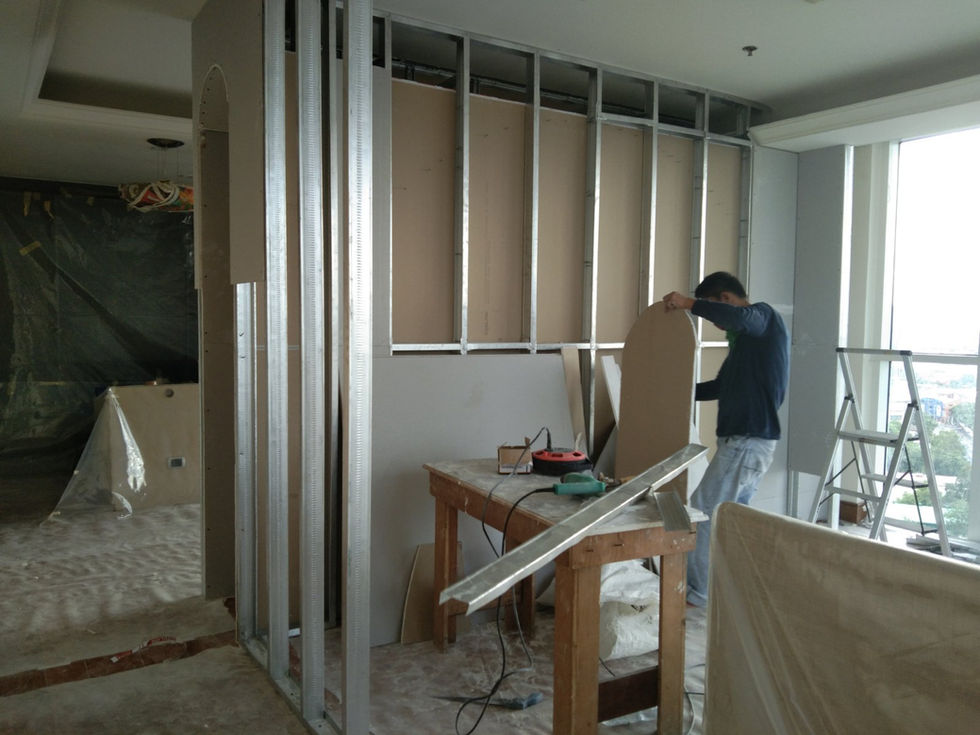 Worker installing drywall on metal studs for AA2000 renovation