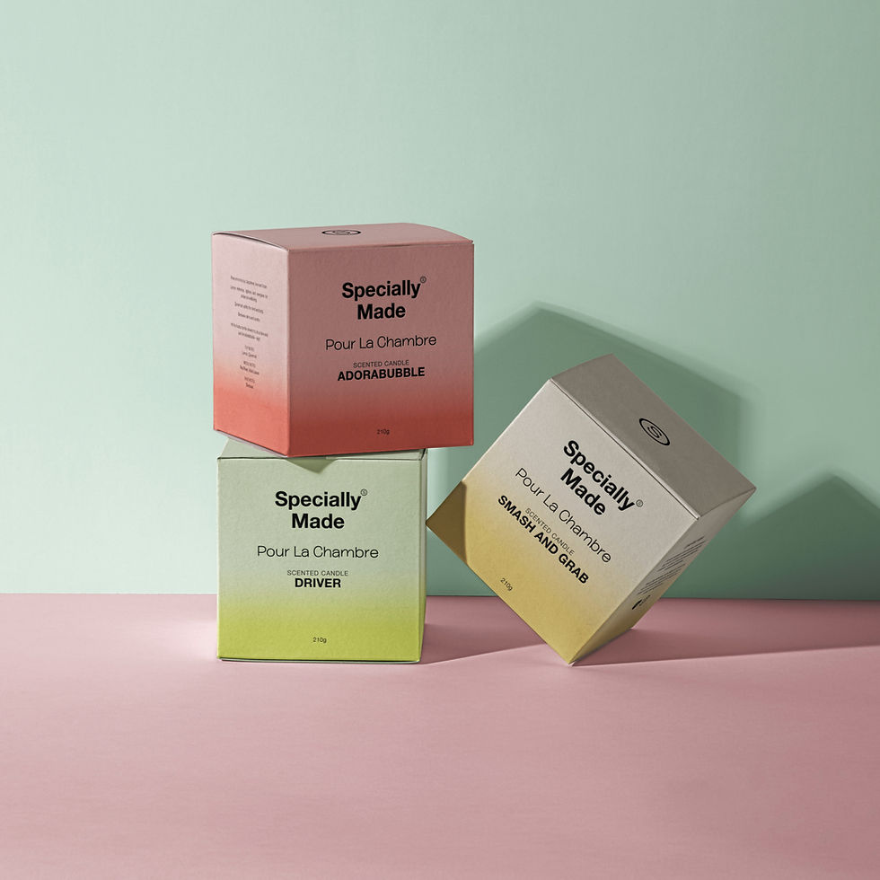 Specially Made Candles in their boxes; green, pink, and yellow containing signature scents.