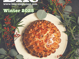 A picture of a golden pie wreathed with green foliage and red berries