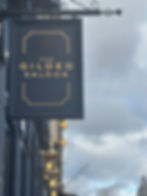 A picture of a navy blue sign against a moody grey sky