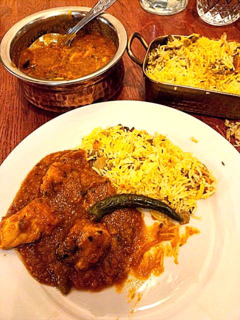 A picture of the chilli garlic chicken on the plate with saffron coloured mushroom pilau rice