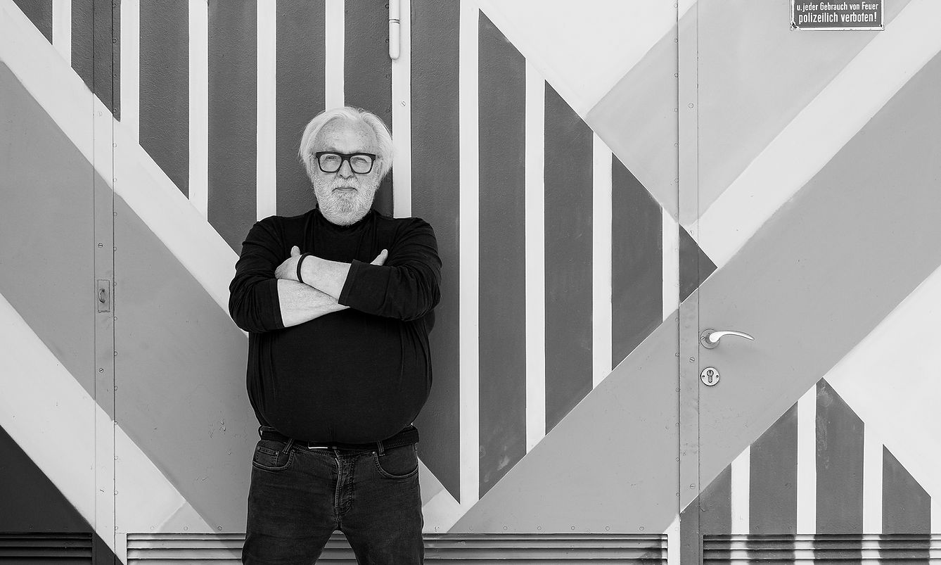 Matthias Riecker vor geometrischer Wand im Aukio Ateliers Kerschlacher Forst, Künstlerportrait