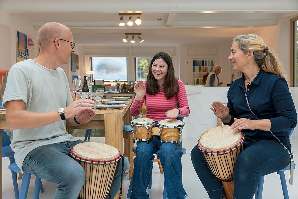 Trommelkurs im Atelierhaus Berg, drei Personen spielen gemeinsam auf Djemben und Bongos im hellen Atelierraum