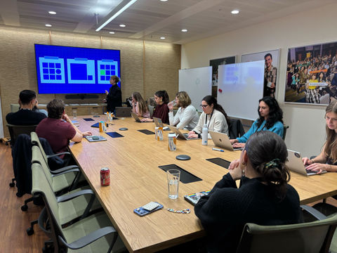 A group of people sitting around a conference table in a meeting room.