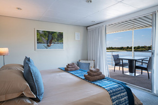 Chobe houseboat-Superior-Cabin-Top-Deck-King-Bed-Setup-with-Outdoor-Chairs-1350x900.jpeg