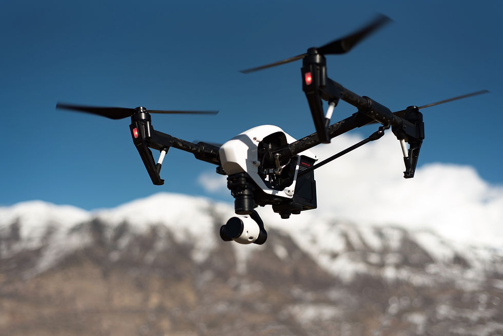 white and black quadcopter hovering under blue skies_edited