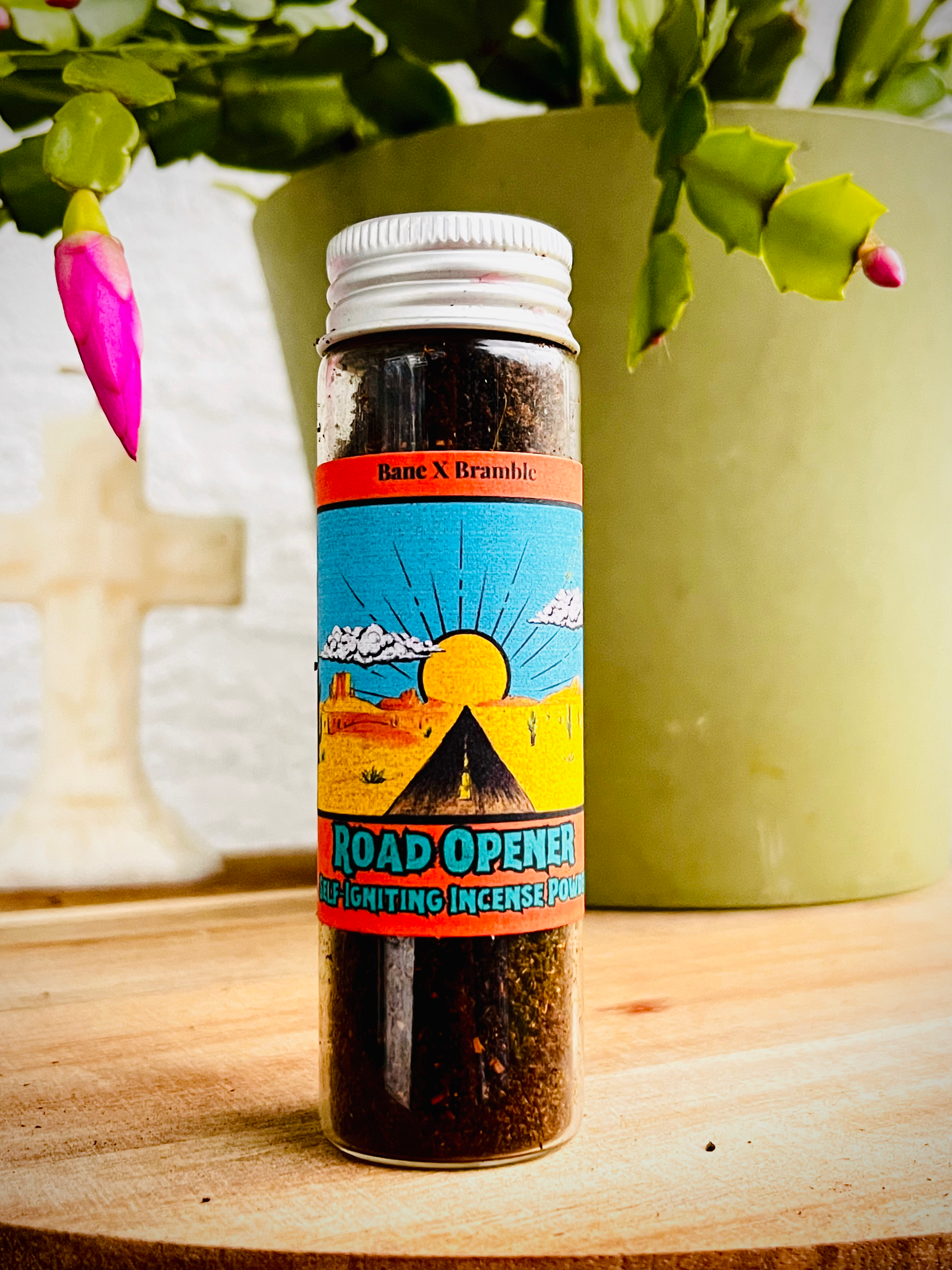 BaneXBramble Road Opener Self-Igniting Incense Powder: a dark orange powder with colorful label with desert road