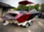 Red and black marine boat with canopy on trailer