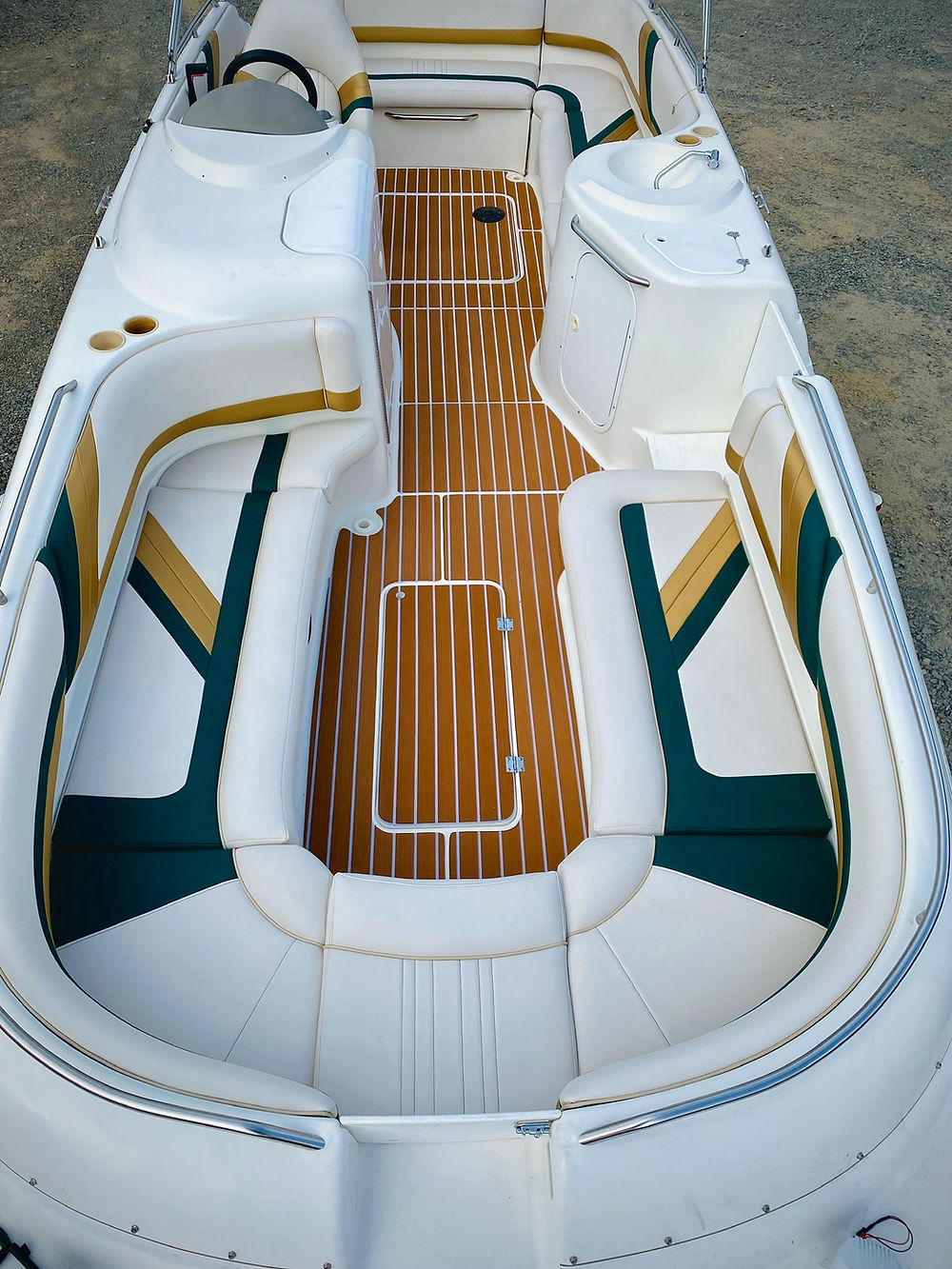Marine boat interior with wood deck and white, green, gold seating