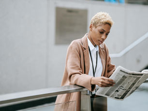 A black businesswoman reading a newspaper.
