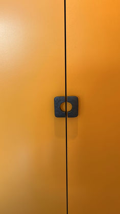 portes de placard peintes en orange vif et poignées en métal anthracite dans un appartement haut de gamme à Paris 16ème