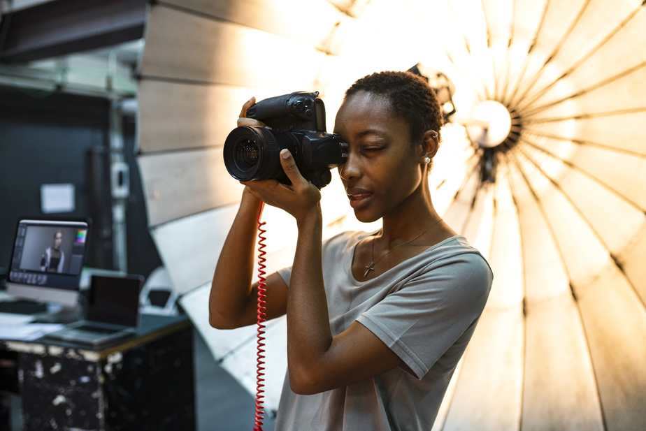 Een fotograaf die geconcentreerd foto's aan het maken is voor een verlichtingsreflectiescherm