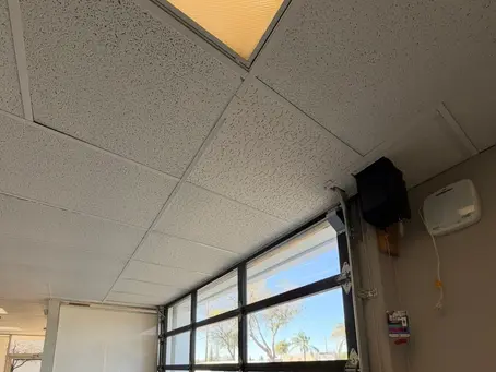 Commercial T-bar suspended ceiling repair in Granite Bay CA after tenant roll-up door installation caused drop ceiling damage and AC air leakage