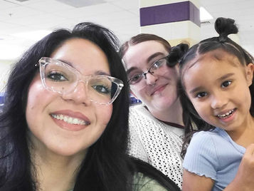 two smiling staff members with a with a female student in