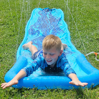 A smiling child on a slip and side