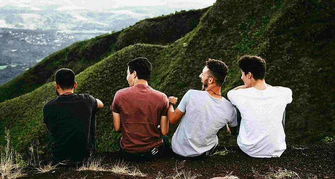 Four men on a hilltop, overlooking a valley, symbolising friendship and collaboration in a speaking ESL lesson plan.