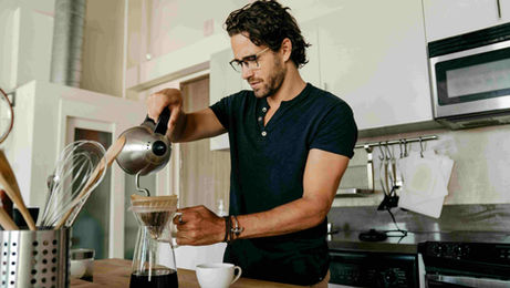A man pours coffee into a cup, illustrating a morning routine for an ESL speaking lesson plan.