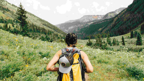 A woman carrying a backpack strolls through a field, representing exploration in a speaking ESL lesson plan about adventure.