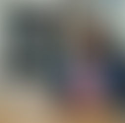 A woman sits at a desk with a laptop, preparing ESL speaking lesson plans for online classes.