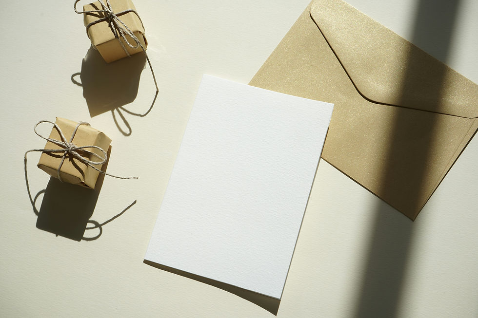 An open envelope beside colorful gift boxes on a white surface, suggesting a festive invitations ESL lesson plan