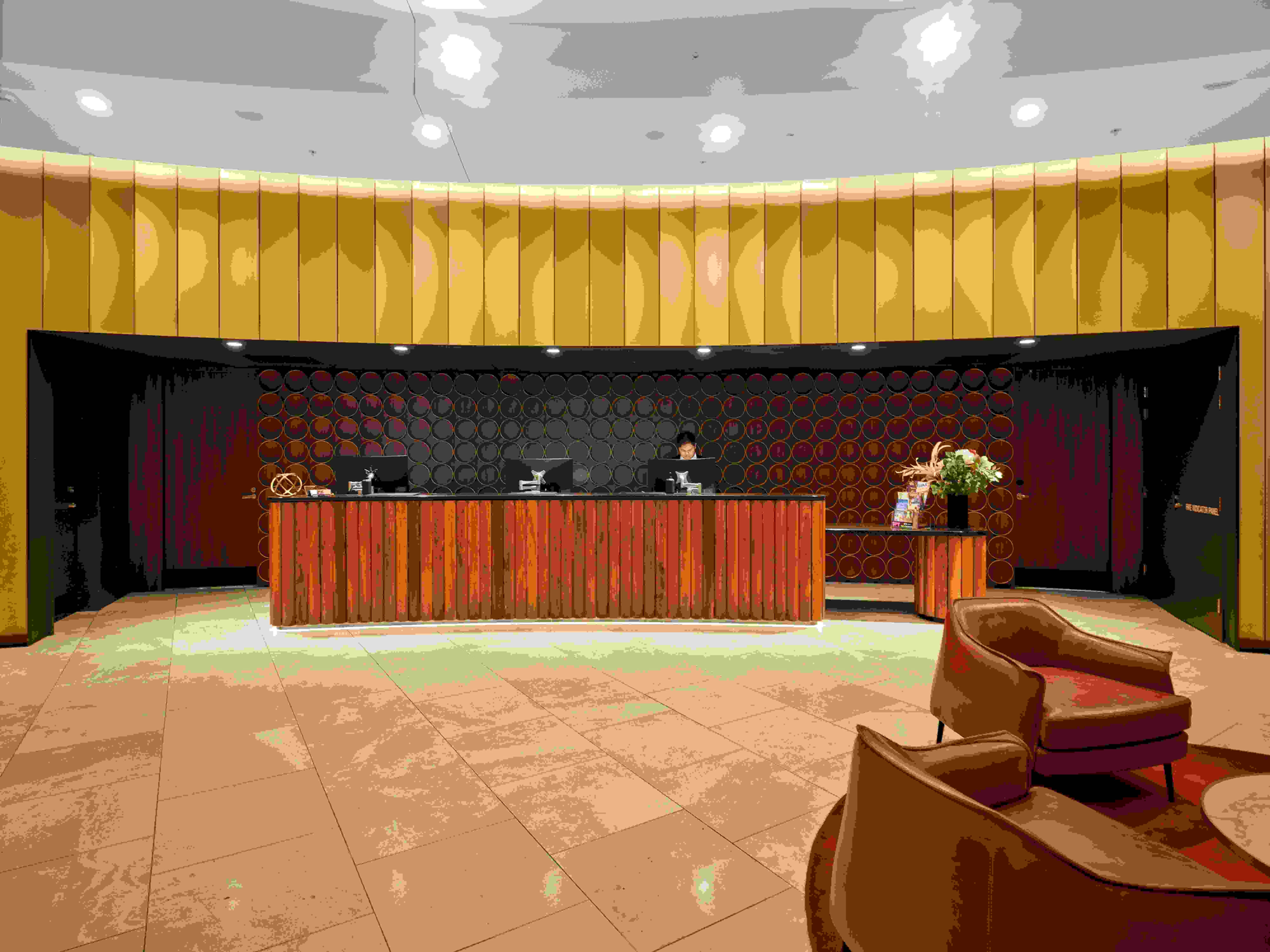 Hotel lobby featuring a reception desk and seating area with chairs for guests.