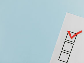 Checklist on paper with a red tick mark, set against a blue background, representing ESL needs analysis.