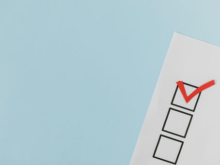 Checklist on paper with a red tick mark, set against a blue background, representing ESL needs analysis.