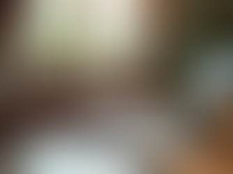 Eye-level view of a writer stretching arms beside a desk with a laptop and notebook