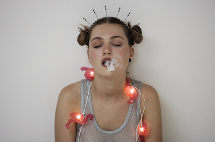 Woman exhaling smoke, wearing flamingo lights and headband