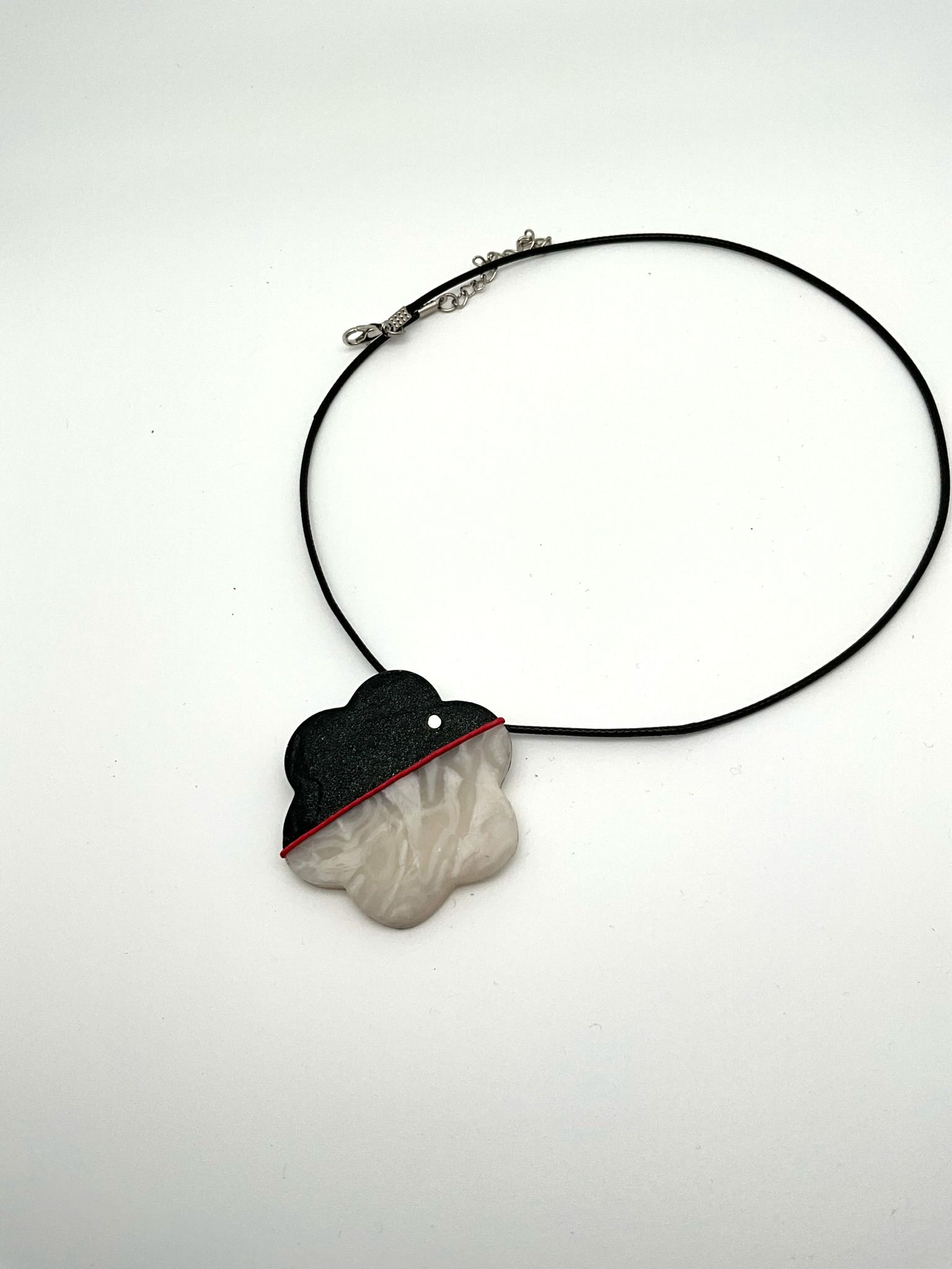 Colgante con forma de flor, mitad blanca nacarada, mitad negra