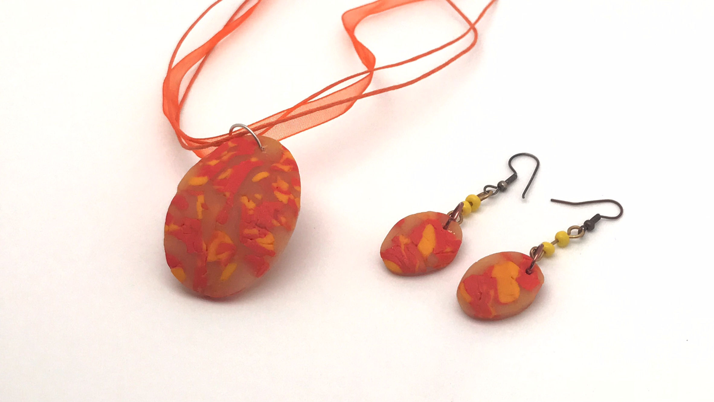 Impresionante conjunto de colgante y pendientes entonos naranjas y rosas. Cordón encerado y organza.