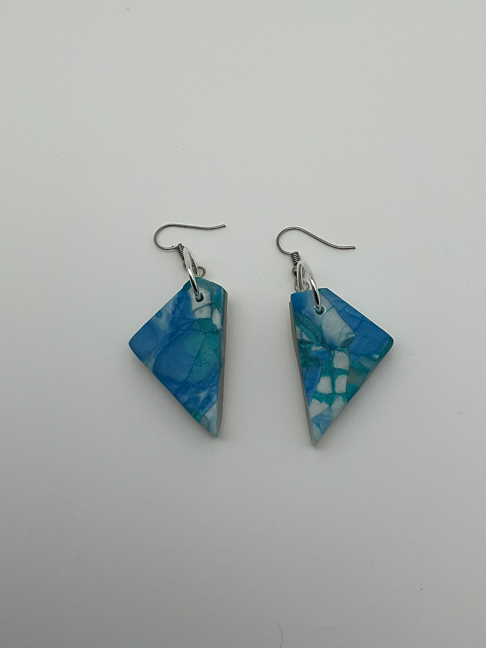 Pendientes azules jaspeados hechos con trocitos de arcilla polimérica con degradados del color azul translúcido