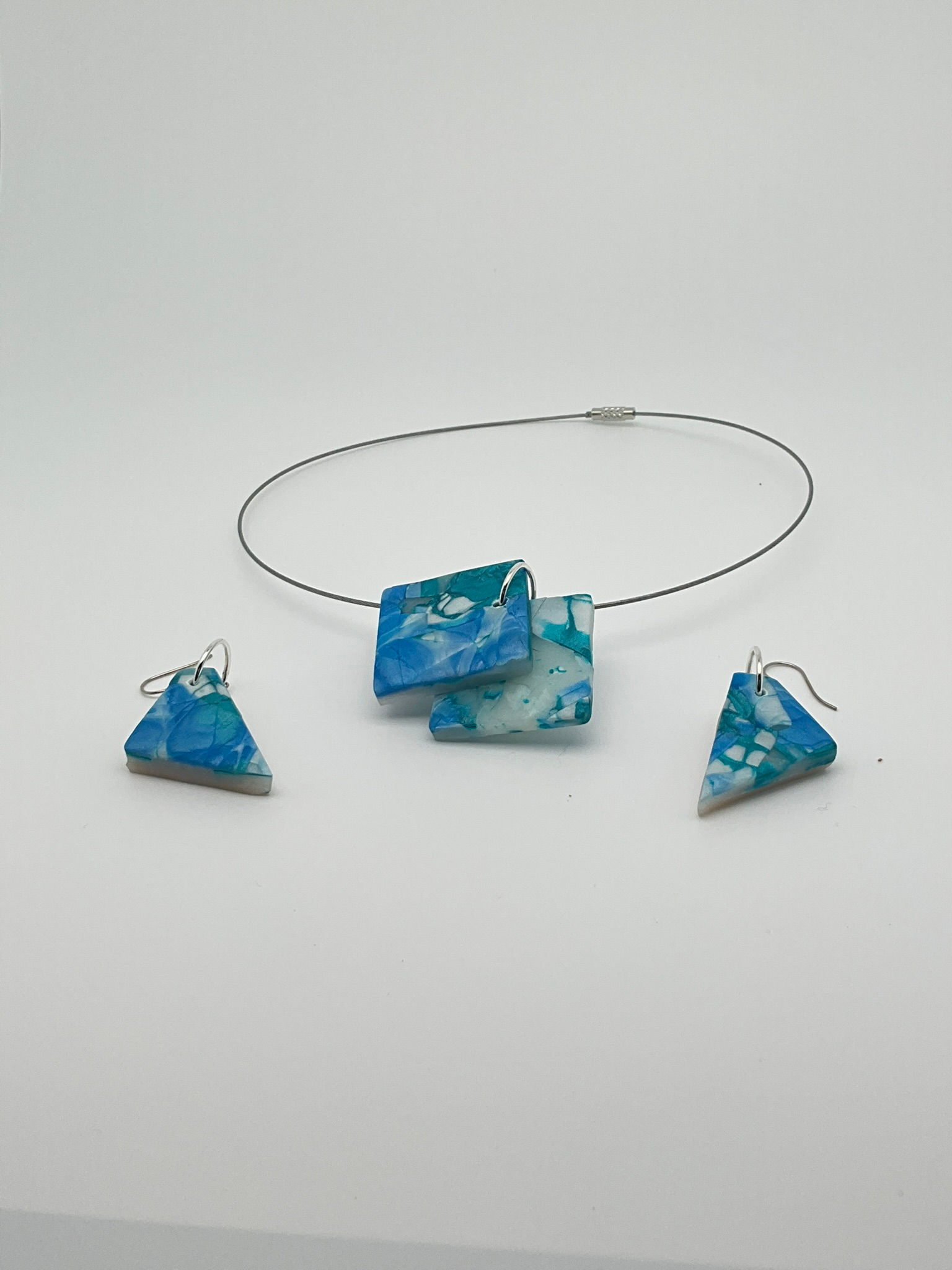 Colgante con dos cuadrados superpuestos y pendientes triangulares de varios tonos azules translúcidos