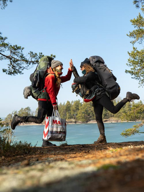 2 kvinnor med ryggsäckar gör high five