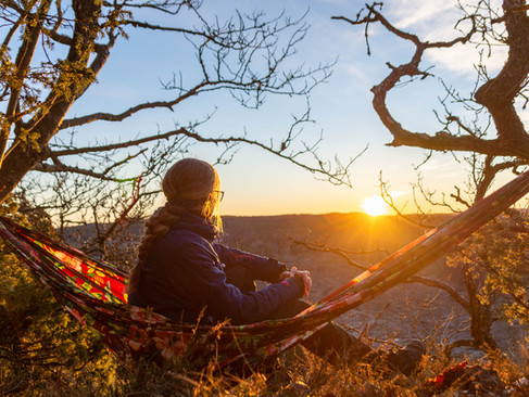 Kvinna I hängmatta vid utsikt i soluppgång 