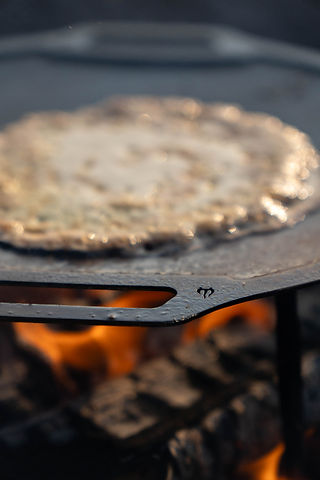 Pannkaka på stekhäll över eld
