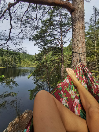 Bara ben i röd hängmatta vid sjö