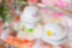 2 mini white crochet hats on a mirror surface
