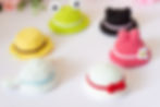 6 different designs of mini crochet hats on a white surface
