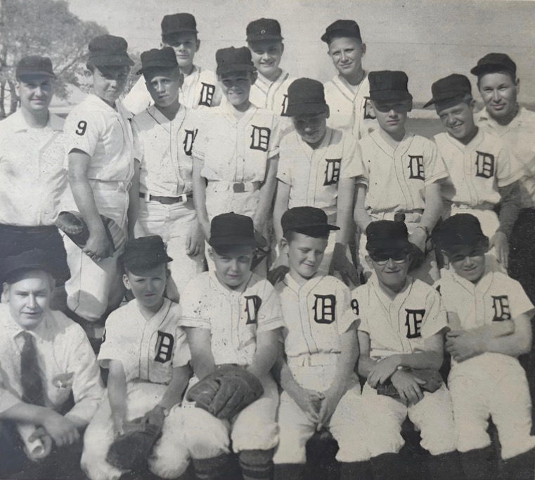 The Tigers lineup features, in the back row: James Wasylk, Fred Sterns, and Tim Berg. In the second row: Coach Donald Wagner, Neil Strzelecki, Jim Gordon, Douglas Winfield, Larry Haselhuhn, Duane Dembny, Patrick Darga, and Manager LeRoy McLennan. In the front row: Coach Norm Haselhuhn, Neil Jones, Thomas Rayha, Gerald Wasylk, Richard Schalk, and Terry Flewelling, 1959
